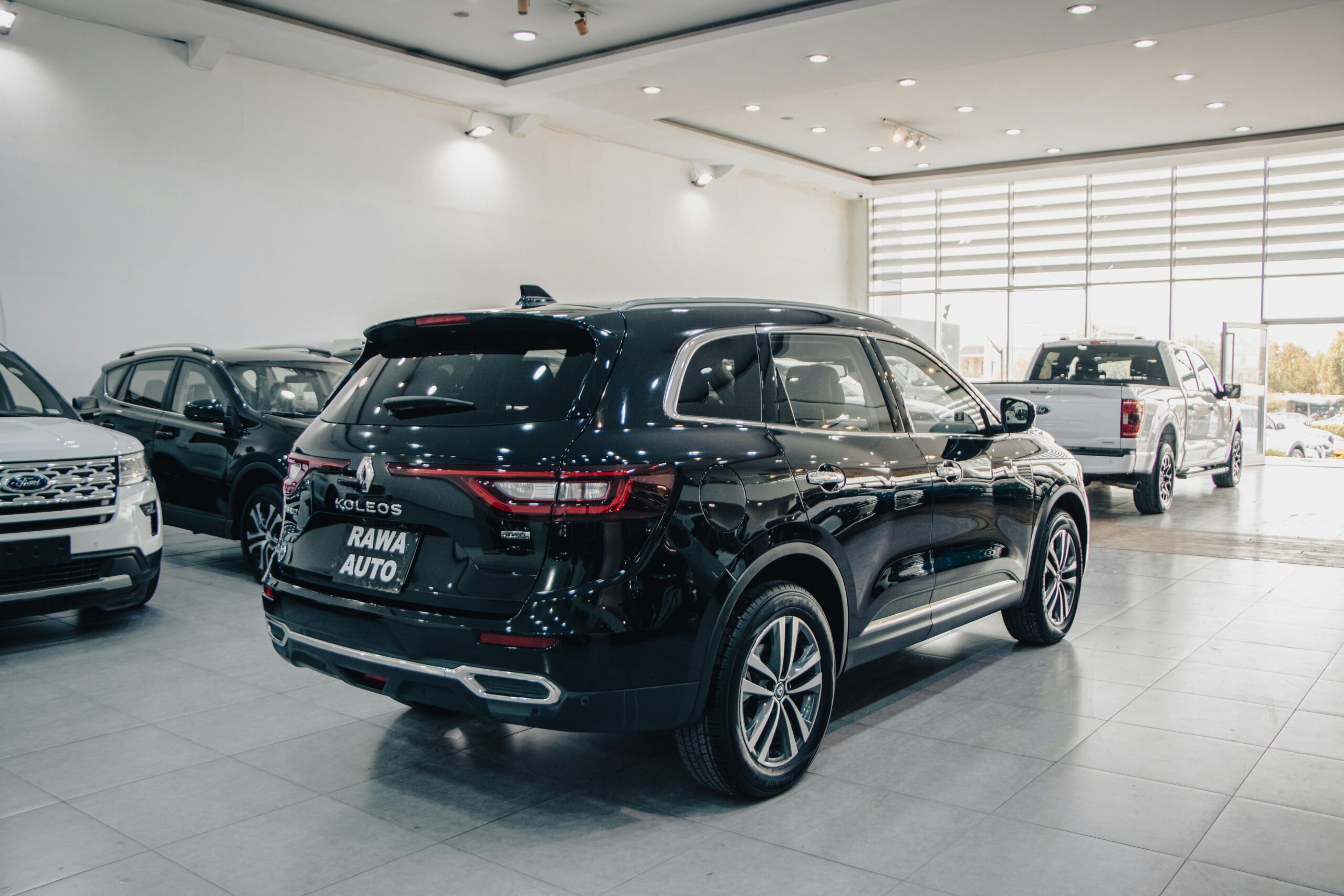 Spacious modern showroom featuring luxury cars on display.